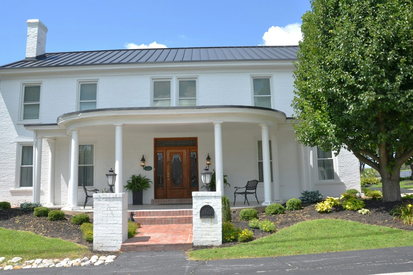 White house with columned porch and freshly painted exterior